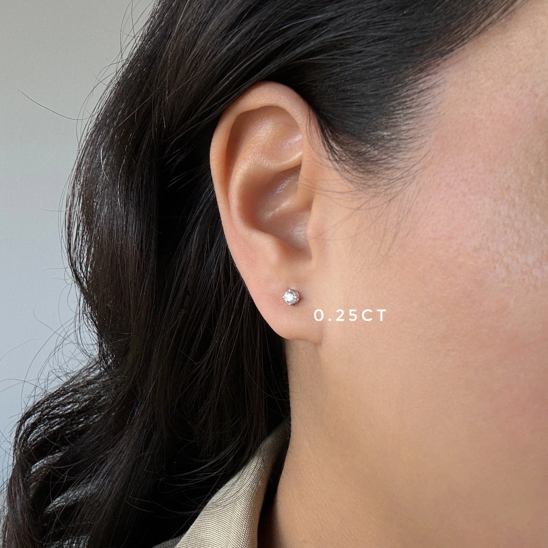 quarter carat diamond stud earrings in white gold on ear