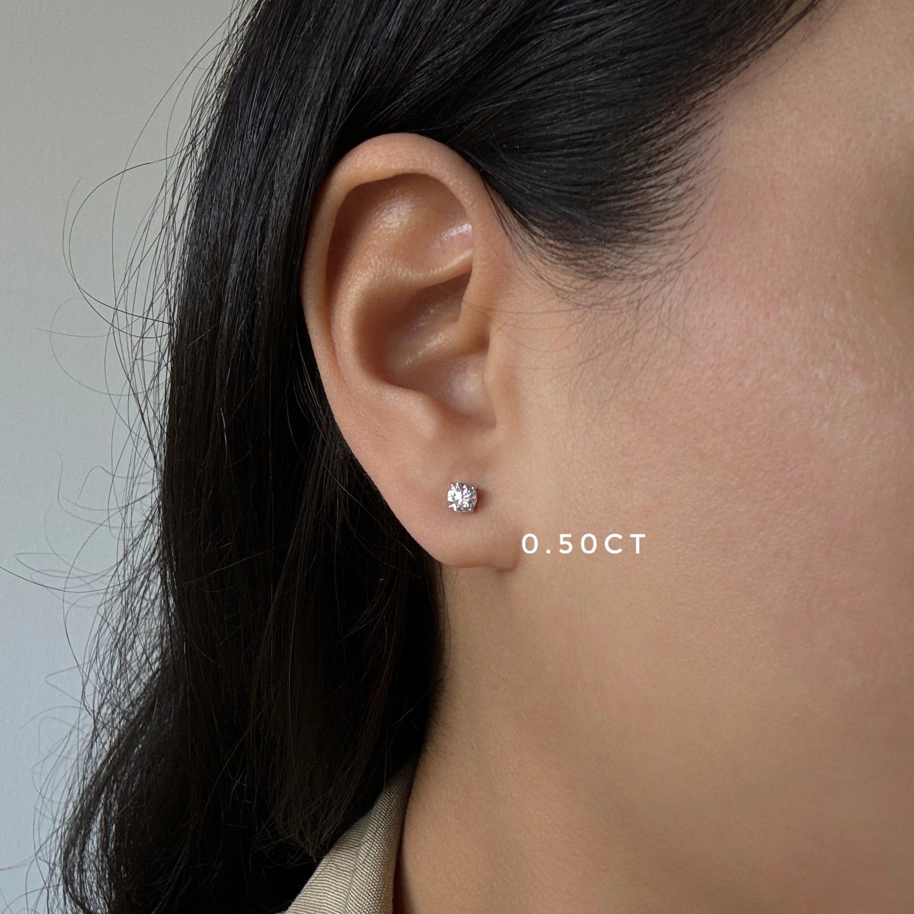 half carat diamond stud earrings in white gold on ear
