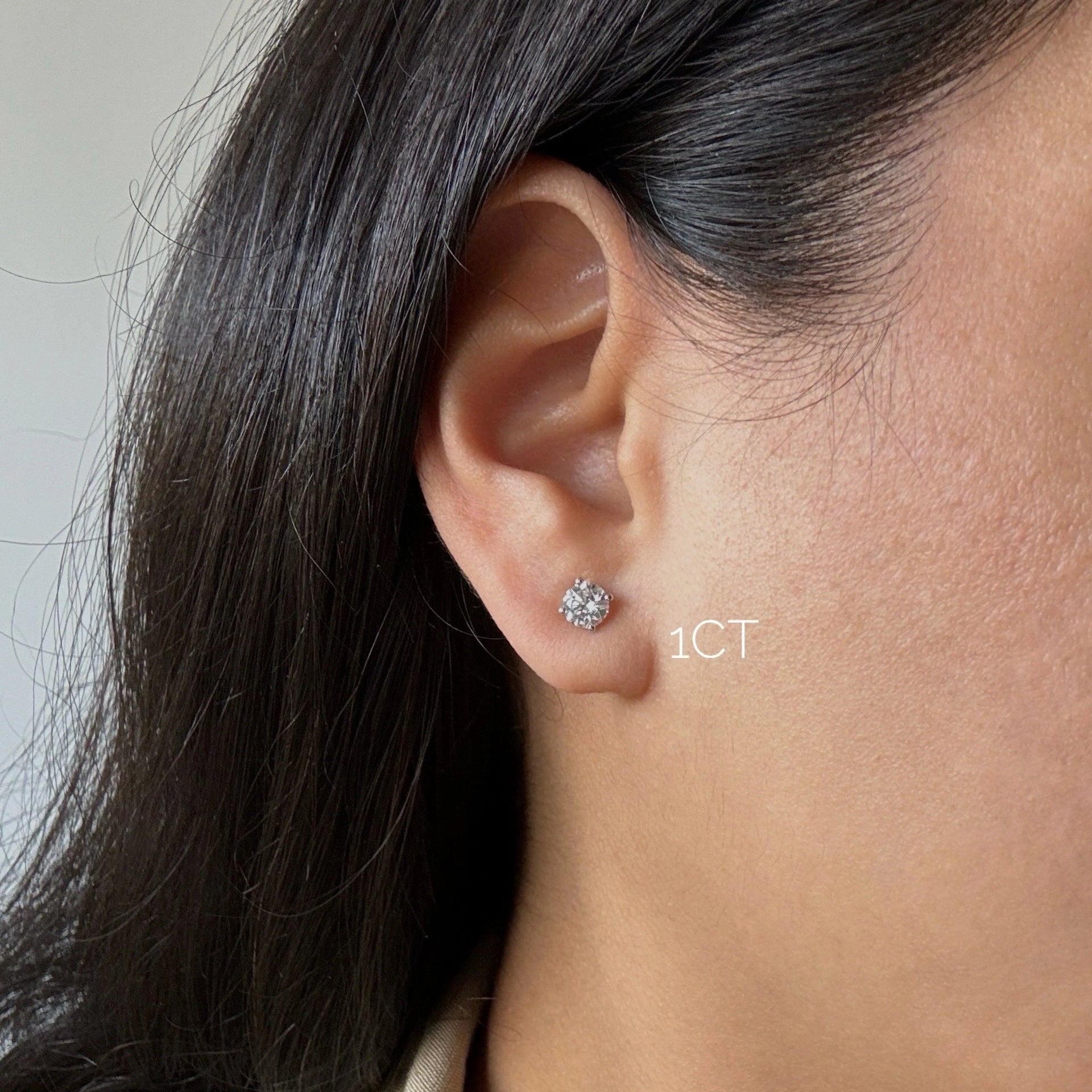 1ct diamond stud earrings in white gold on ear
