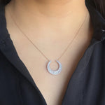 diamond moon shaped necklace in yellow gold with round and baguette diamonds