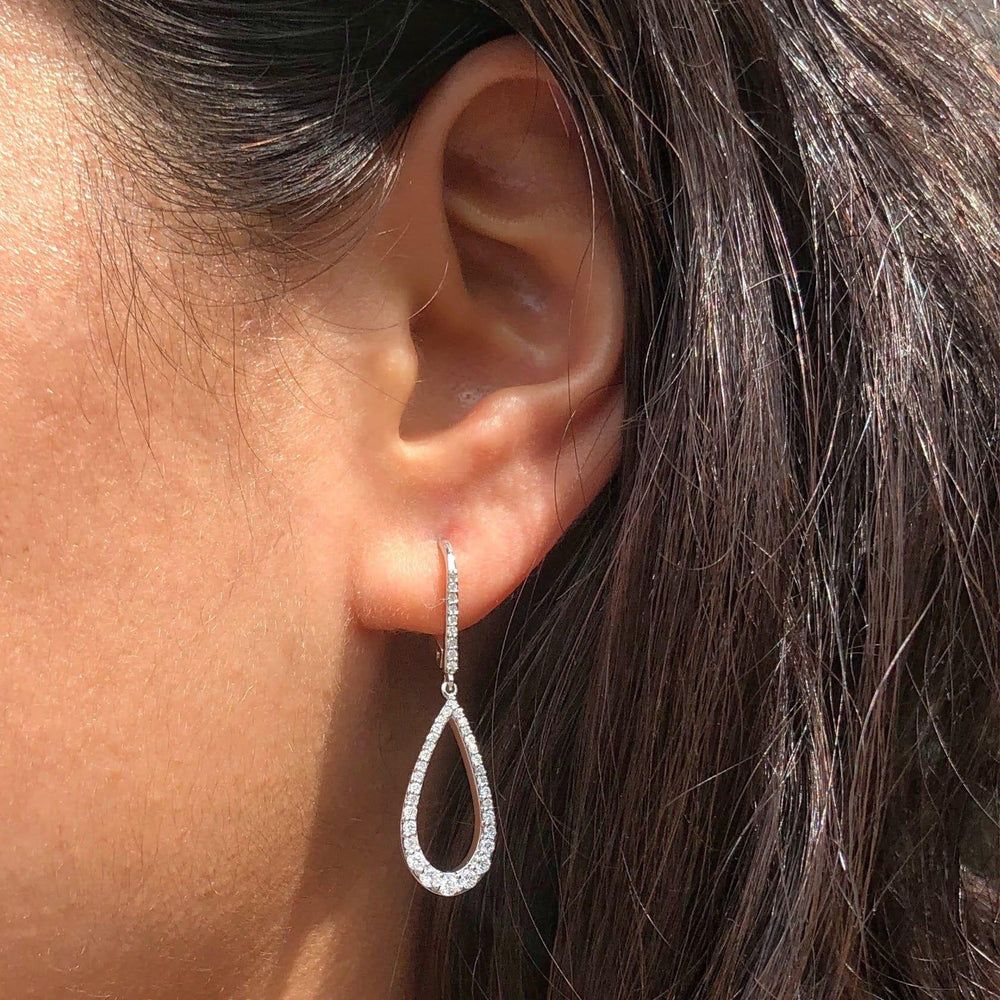 diamond pear drop earrings displayed on an ear