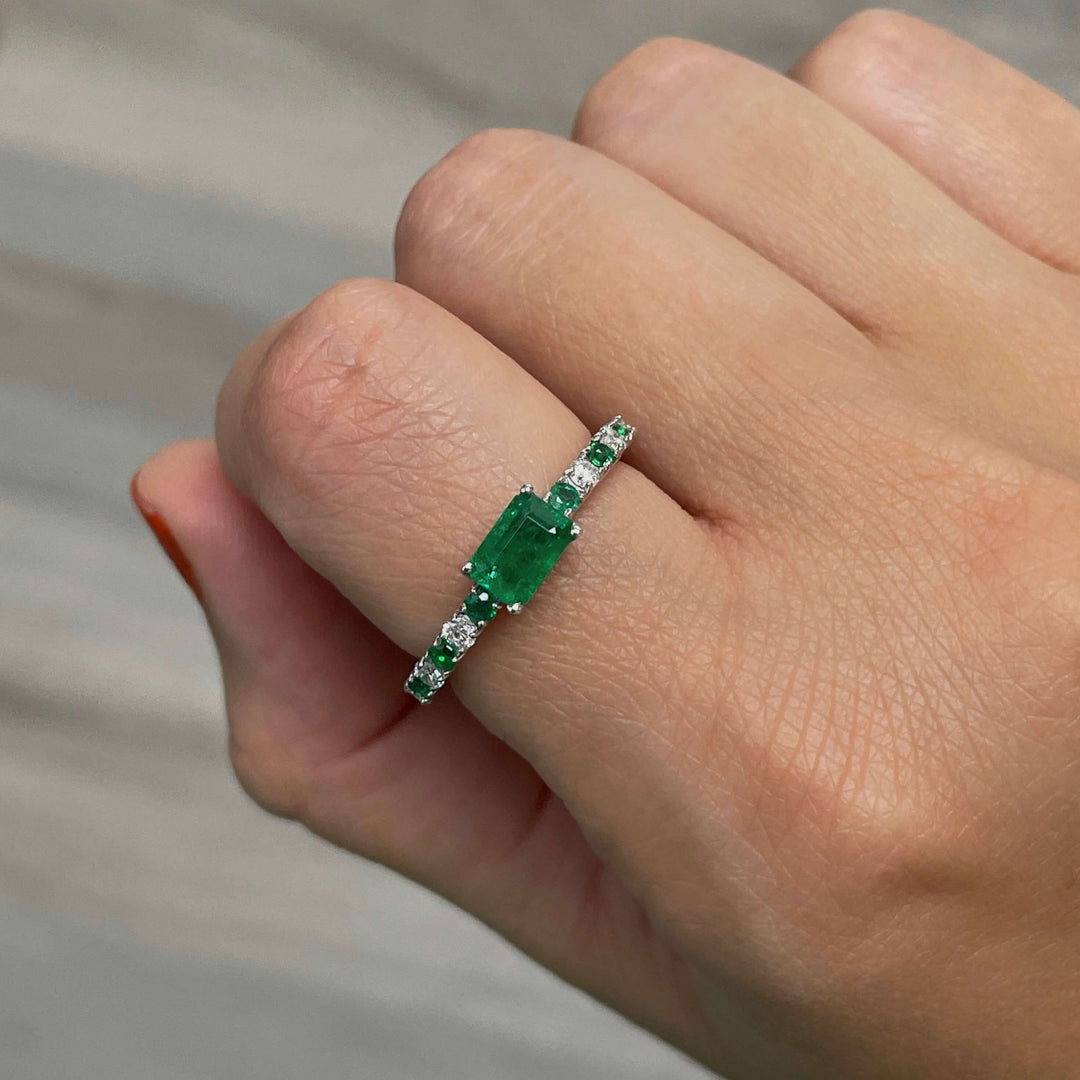 emerald center stone ring with alternating round diamonds and emeralds in 14k white gold