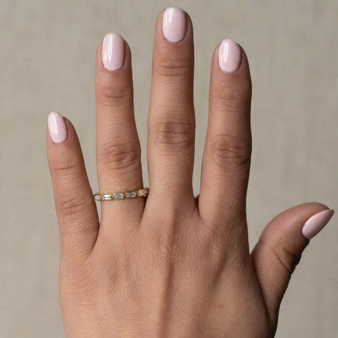 yellow gold diamond band ring with sideways baguette diamonds set between two prongs going half way eternity worn on a womens hand