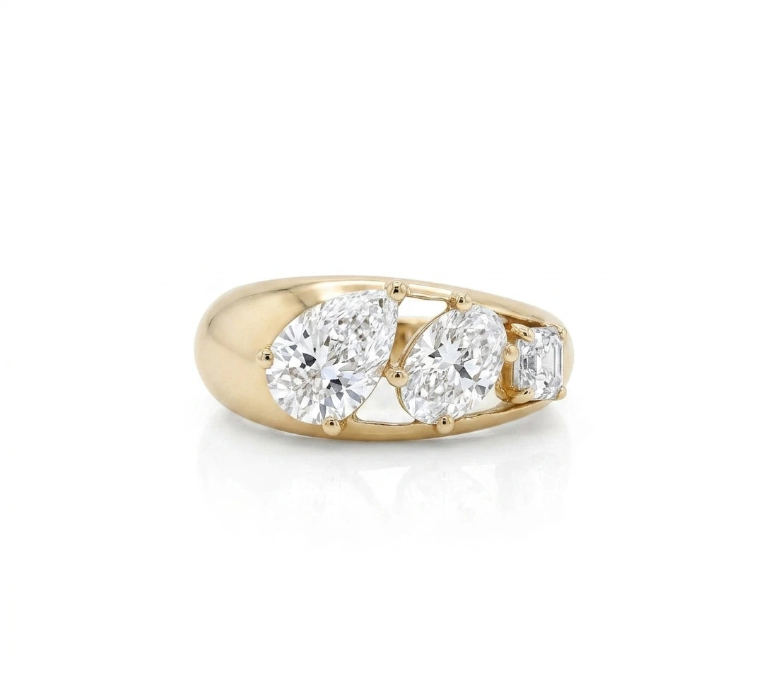 yellow gold three stone ring featuring a pear cut diamond, an oval cut diamond, and an Asscher cut diamond descending in size shown from its side view