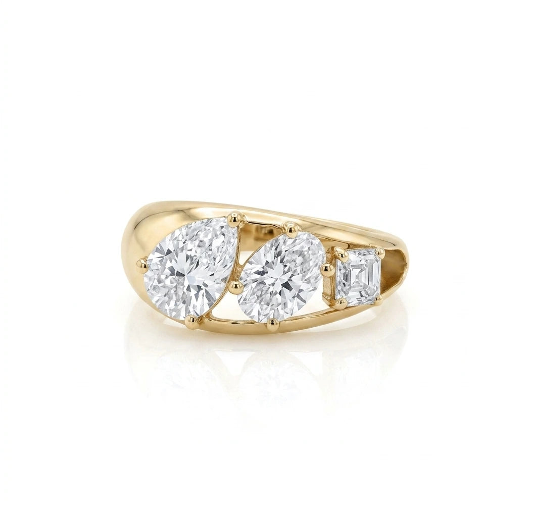 yellow gold three stone ring featuring a pear cut diamond, an oval cut diamond, and an Asscher cut diamond descending in size.