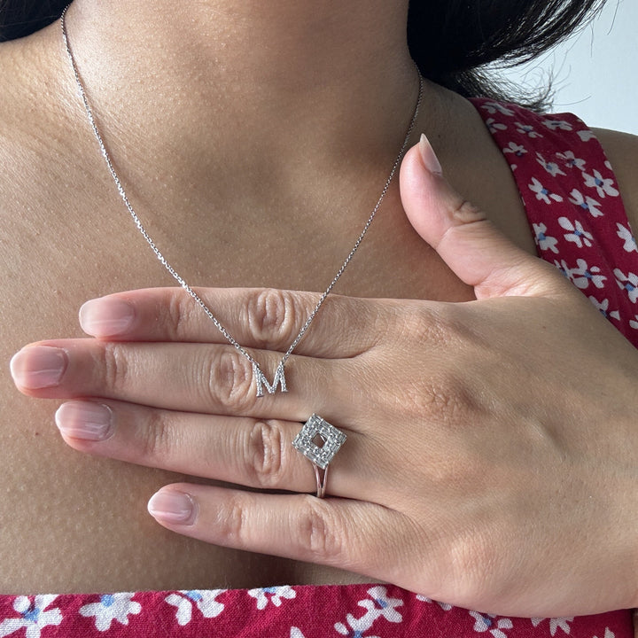 diamond M initial white gold necklace worn with a white gold diamond cocktail ring with baguettes