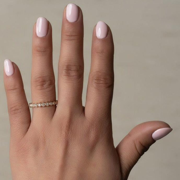 rose gold diamond band ring in a honeycomb design worn on a hand