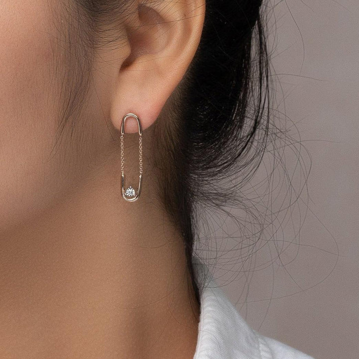rose gold chain paperclip earrings with a diamond worn on an ear 