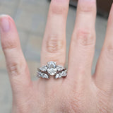 round diamond and marquise diamond wedding band ring with gap in the middle stacked with 3 stone oval diamond engagement ring