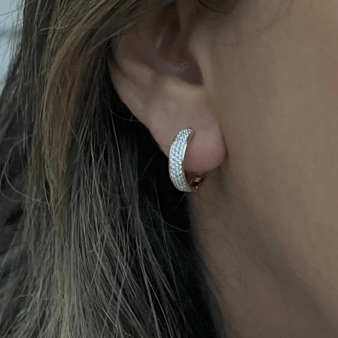 three rows of diamonds in 14k gold hoop earrings on model