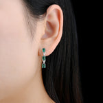 Load image into Gallery viewer, Three Stone Emerald and White Zircon Drop Earrings in Sterling Silver on model
