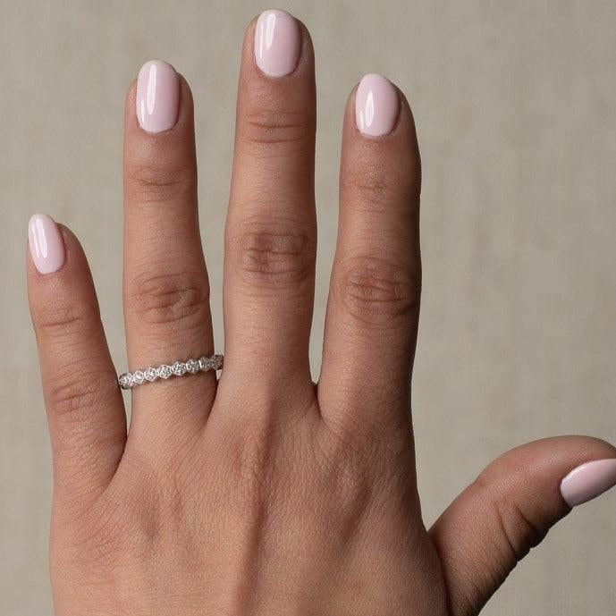 rose gold diamond band ring in a honeycomb design worn on a hand