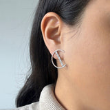 half circle motif earrings with a bar going through the circle. Bar has 5 diamonds