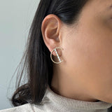 half circle motif earrings with a bar going through the circle. Bar has 5 diamonds.