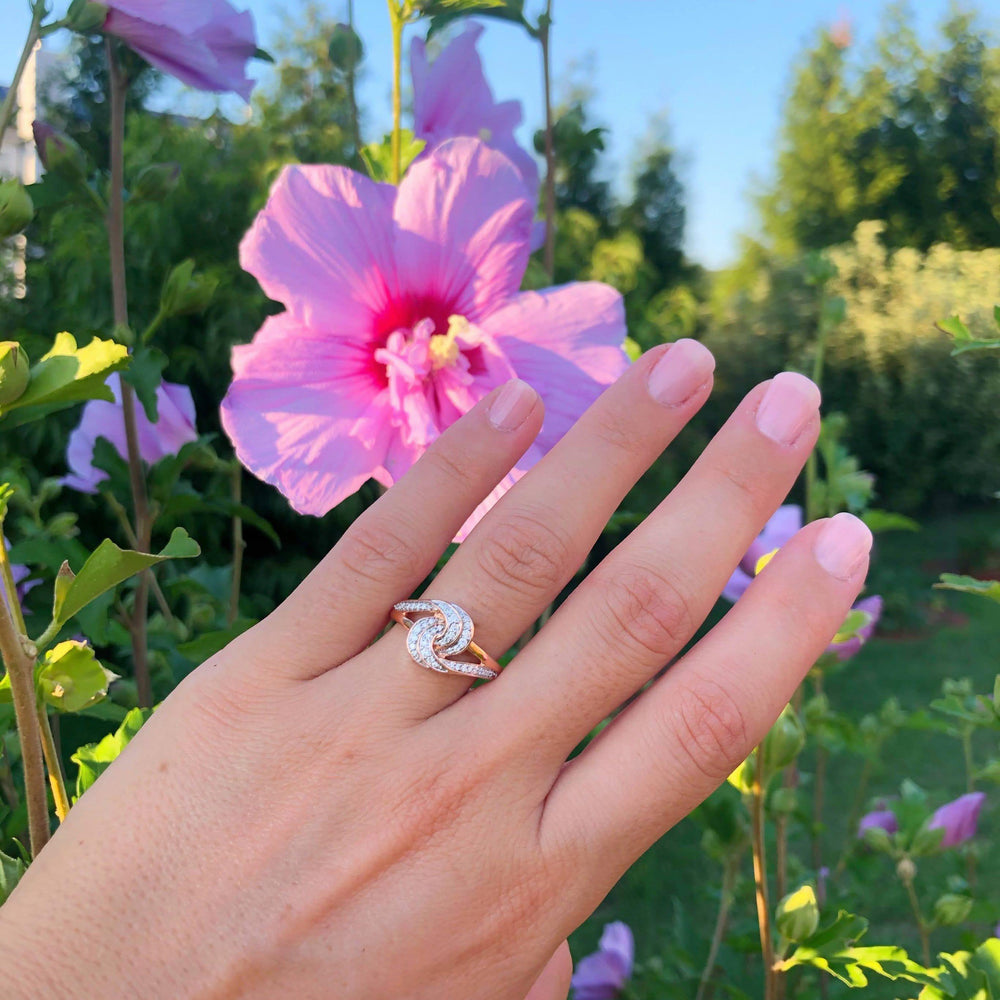intertwined diamond ring worn on a hand