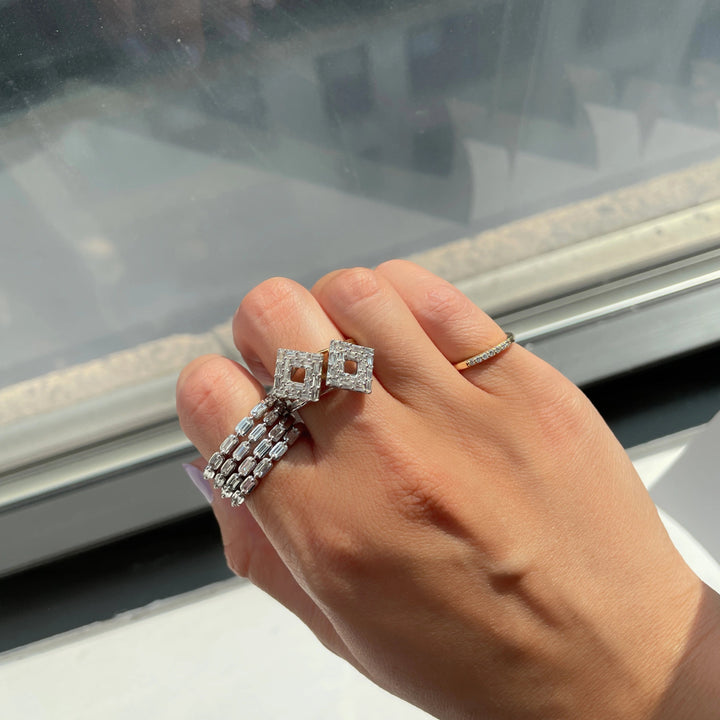 stacked white gold baguette diamond band rings worn with baguette diamond rings in a diamond shape and pinky ring