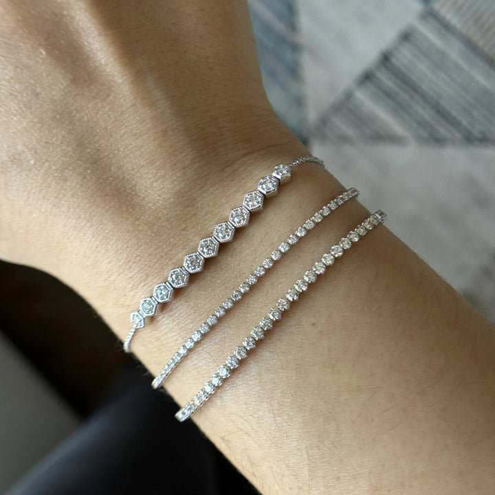 stacked white gold diamond bracelets with honeycomb design and tennis bracelets