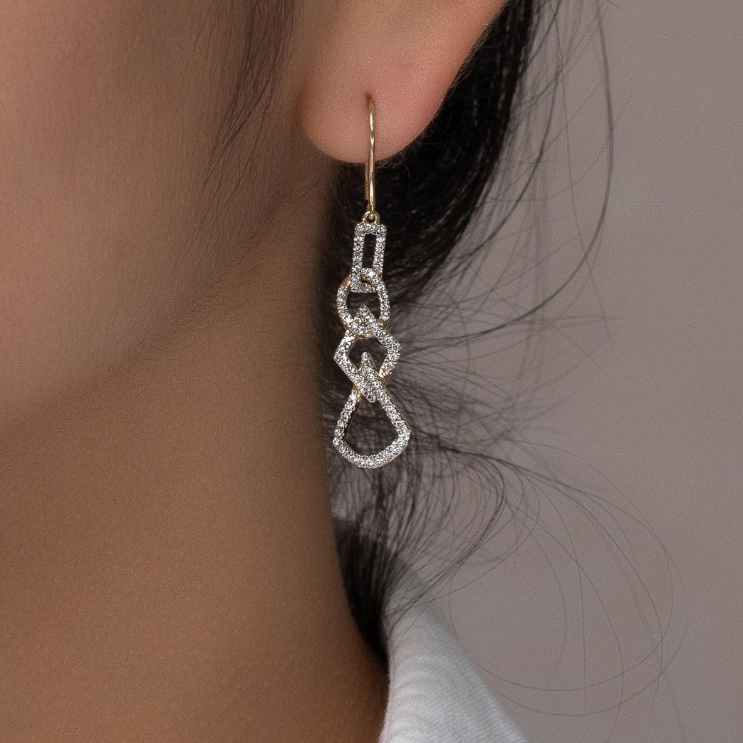 unique jewelry, unique earrings, fashion jewelry, fashion earrings, diamond earrings in yellow gold, dangling earrings, dangling diamond earrings, drop earrings, diamond drop earrings, dangling drop earring with a design of geometric shapes intertwined with each other. Earrings have a fishhook back.