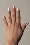 gemstone ring with pastel pink tourmaline and pastel blue swiss blue topaz and white sapphires in different shapes. Blue topaz in oval shape as the center stone with semi eternity alternating pink tourmaline and white sapphire in round shape. Metal is 18k gold over silver vermeil. Stackable ring. Ring on model.