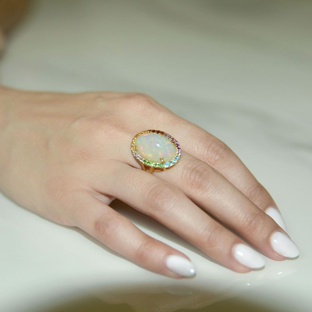 very large opal ring with multi colored gemstones in 14k yellow gold. opal has very strong play of color