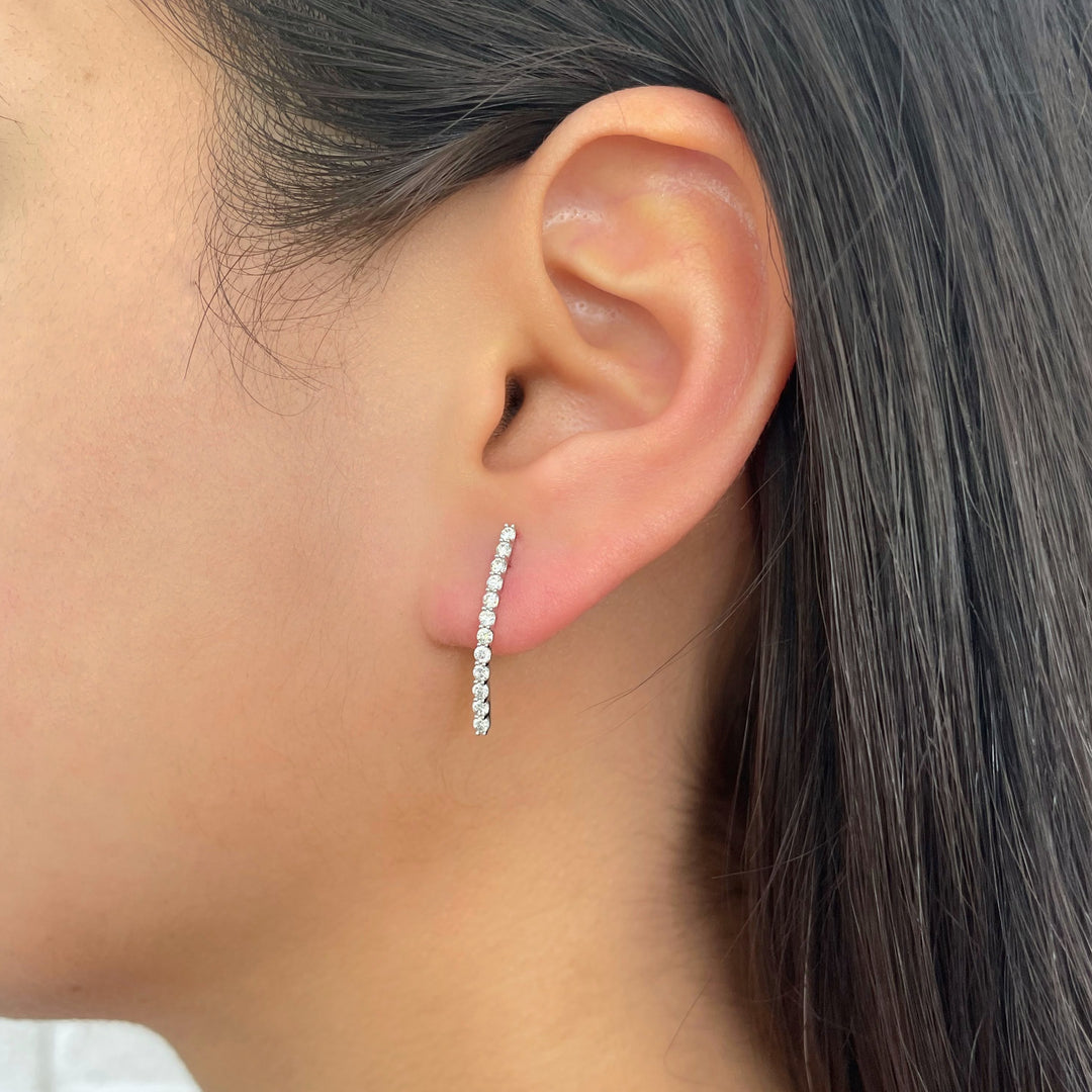 diamond bar stud earrings in white gold on a model